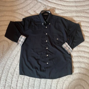 Skjorta från Burberry  - Säljer nu denna eleganta skjorta från märket BURBERRY, skick 8/10 lite noppig men annars inga tecken på användning, storlek M passar som en M. Kvitto finns kom privat om ni vill se.