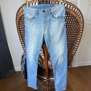 Diesel jeans - Säljer ett par ljusblå Diesel Buster jeans med klassisk femficksdesign och diskret tvättad look. Jeansen har normal passform och raka ben, tillverkade i stretchig denim för extra komfort. Perfekta för dig som gillar en avslappnad men snygg stil. Skick 9/10 (knappt använda). Jag kan gå med på lägre pris vid snabb affär. Skriv om du har några frågor!
