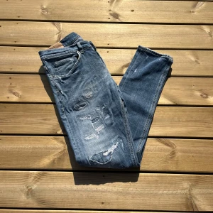 Dondup George - Säljer nu dessa väldigt snygga Dondup George jeans i storlek w31. Skicket på dessa är väldigt bra utan några skador eller defekter 9/10. Måtten på dessa är midja 40cm. Lår 24cm. Ytterlängd 100cm. Innerlängd 80cm. För fler frågor eller liknande är det bara att skriva. 