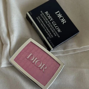 Dior blush Rosy Glow Rouge 001 Pink - Dior Rosy Glow rouge i nyansen 001 Pink. Ett puderrouge med ikonisk Dior-logga i pressad design och spegel i locket. Ger en fräsch rosa ton och naturlig glow till kinderna. Kommer i original förpackning. Köpt för 495kr