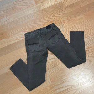 Grå Tight Long John jeans från Nudie - Säljer ett par gråa Tight Long John jeans från Nudie Jeans. Modellen är slim. Stilrena gråa jeans till sommaren, hösten, våren och vintern! Storlek 29/32 och är i bra skick. Skriv vid funder 
