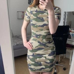 Camo tight kortklänning H&M Divided - Säljer en tight kortklänning från H&M Divided i camouflagemönster. Klänningen har korta ärmar, rund halsringning och figurnära passform. Perfekt för dig som vill sticka ut med en cool stil. Materialet är mjukt och stretchigt, samt otroligt bekväm! Endast använd 2ggr💕