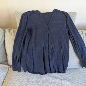 Blå blus med vita prickar från Esprit - En tunn och luftig marinblå blus med små vita prickar i skönt material från Esprit. Jag är ca 170 cm för referens. Vid köp av flera klädesplagg av mig samfraktar jag såklart!