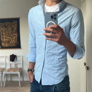 Ralph Lauren Skjorta (pris diskuterbart) - !! NY SKICK !!Klassisk ljusblå skjorta från Ralph Lauren i SLIMFIT med button-down krage och broderad logga på bröstet. Skjortan har lång ärm, knappar framtill och är tillverkad i mjuk bomull. Perfekt för en clean och stilren look.
