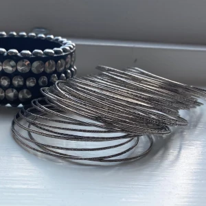 Set med tunna silvriga bangles - Säljer ett stort set med tunna, runda armband i silverfärg. Så snygga!! Köpta på Sellpy men aldrig använda av mig. Diameter i cm = 7. Hör av er om ni har några frågor!💞💞