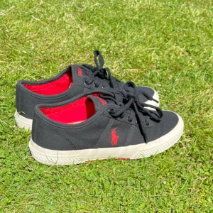 Klassiska Ralph Lauren-sneakers i mycket fint skick. Stilren design som passar både till vardag och lite mer uppklätt. - Sparsamt använt skick!
