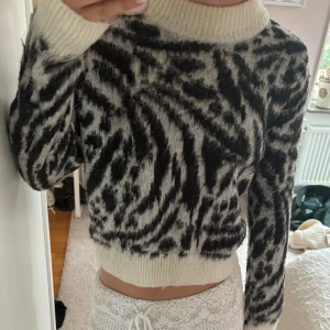 Zebramönstrad stickad tröja H&M XS - Säljer en fluffig stickad tröja från H&M i storlek XS. Tröjan har zebramönster i svart och vitt. hög krage och ribbade muddar. Jättefin i bra skick! Skriv för frågor eller funderingar!