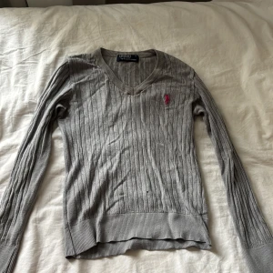 En grå Ralph lauren tröja - En grå stickad polo tröja som är långärmad  Ganska bra skick förutom att den har ett mini hål vid magen