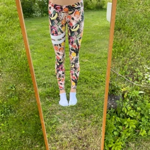 STRONGER träningstights med fruktmönster - Säljer ett par riktigt färgglada leggings med fruktmönster. Använt ett fåtal gånger. Orginalpris 600kr. Tight passform och hög midja som man kan vika ner för en lägre variant. Perfekta för träning eller när du vill sticka ut. Materialet är stretchigt och bekvämt.
