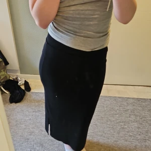 Svart långkjol från Bik Bok - Säljer en svart långkjol från Bik Bok i stretchigt och mjukt material. Kjolen har en enkel och stilren design med rak passform och är perfekt för dig som gillar minimalistisk stil.