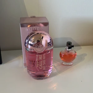 Please Call Me parfym rosa flaska - Säljer en parfym från Please Call Me i en rosa flaska med metallicrosa lock och tillhörande ask. Parfymen har en modern design med text på flaskan. Medföljer även en mindre hjärtformad parfym som luktar äpple. Båda från märket sence, köpta på gekås. Båda för 45 kr. 