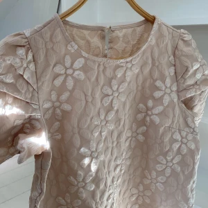 Champangefärgad blus  - Såå fin champangefärgad blus med blommiga broderier. Blusen har rund halsringning och en liten knapp i nacken. 🌹🌹