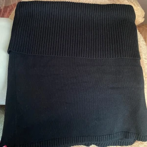 Svart stickad kjol Gina Tricot XL - Svart stickad kjol från Gina Tricot i storlek XL. Kjolen är kort och har bred ribbad midja samt ribbade detaljer vid nederkanten. Enkel och stilren design som är lätt att matcha med olika toppar. Använd en gång bara så precis som ny 