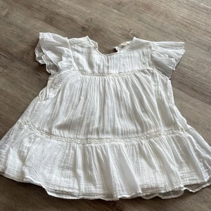 Vit volangblus  från Gina Tricot - Super fin topp från Gina Tricot. Super fin nu till sommaren eller andra tillfällen. Har bara använt den få tillfällen, den är  ny tvättad. 