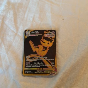 Mew VMAX Fusion Strike - Cool och glittrig Mew VMAX Fusion Strike Pokémonkort! Perfekt för samlare och fans som vill boosta sin samling med en sällsynt och kraftfull kort. Korten är i fint skick och passar både nya och erfarna spelare.