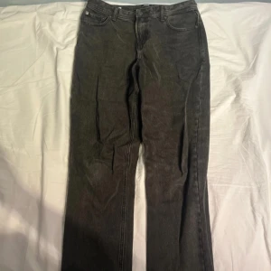 Svarta jeans från Jack & Jones - Säljer ett par svarta jeans från Jack & Jones med klassisk femficksdesign och raka ben. Jeansen har normal passform och är tillverkade i bomull med en snygg tvättad finish. Perfekta för dig som gillar en enkel och stilren look.