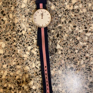 Daniel Wellington klocka med randigt band - Klockan är trasig säljes om man vill laga eller ha en del av klockan