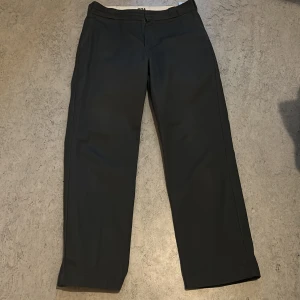 Dickies 874 mörkgrå kostymbyxor/workpants - Klassiska mörkgrå Dickies 874 kostymbyxor med rak passform och midja. Byxorna har hällor för bälte, dragkedja och knapp framtill. 33/32