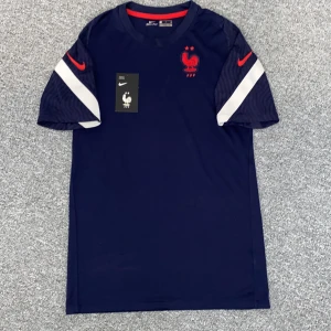 Frankrike Nike fotbollströja marinblå S - Marinblå Nike Dri-FIT fotbollströja för Frankrikes landslag. Den har ett ”tightare/slimfit” passform. Med original lapp. Vid frågor, funderingar eller annat hör av dig!