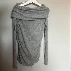 Grå offshoulder tröja från Zara - Supersnygg grå offshoulder tröja från Zara med lång ärm och draperad krage. Tröjan sitter mot kroppen och är seethrugh på ett snyggt sätt. ALDRIG ANVÄND!!🖤🖤skriv om ni vill se tröjan på!!