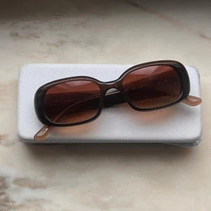 Bruna solglasögon från Chimi - Så coola och snygga bruna solglasögon från Chimi med rektangulära bågar och bruna tonade glas. Bågarna har en stilren, chunky design med märkets logga på sidan. Perfekta för att lyfta en basic look. Modellen heter lax Brown, finns inte kvar på hemsidan längre. Solglasögonen är inköpta förra året för 1400 kr. Säljer de nu eftersom de inte kommit till stor användning. De är alltså nästan helt i nyskick. 