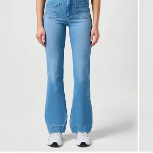 Ljusblå bootcut jeans från Wrangler - Säljer ett par ljusblå bootcut jeans från Wrangler med framfickor. Storleken är W25 L32 och passar mig som har 34/36 i jeans                                            