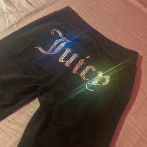 juicy couture byxor  - byxor från Juicy Couture med strasstext på baksidan. Byxorna har snörning i midjan och en liten logga på höften. Köpta för 1200kr på Juicy Coutures egna hemsida. Storlek XS men passar S och även M. Säljer för dom blivit lite stora på mig och inte kommer till någon användning längre
