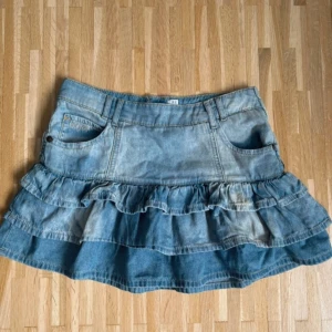 Volang jeanskjol - Jättefin jeanskjol med volanger! Dragkedja på sidan. Det står storlek S, men skulle säga att den är liten i storleken och kan passa XS också. Bra skick! För liten på mig därför är den uppknäppt på sista bilden