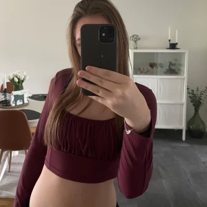 Vinröd topp - Vinröd långärmad topp som är croppad och uringad med struktur över bröstet. Nyskick och endast testad. 💕