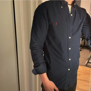 Ralph Lauren Skjorta - Tja säljer en Ralph lauren skjorta i färgen marinblå och i storlek M. Nypris 1595 KR mitt pris 299 KR. Inga defekter som hål eller fläckar. Skriv vid frågor eller funderingar.