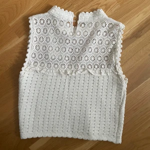 Vit spetsig linnetopp från Zara - Superfin vit linnetopp från Zara med broderade blommor upptill och virkad nedtill. Toppen är ärmlös och har en hög hals. Toppen är i nytt skick och helt oanvänd. Säljer den för att den är för liten. Köparen står för frakt.💕