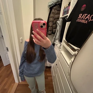 Blå stickad tröja från Vero Moda - Mysig blå stickad tröja med lång ärm. Tröjan har en loose passform och är perfekt för dig som gillar en avslappnad men ändå trendig stil. Ribbstickade muddar vid ärmslut och nederkant. Superenkel att matcha med jeans eller kjol.