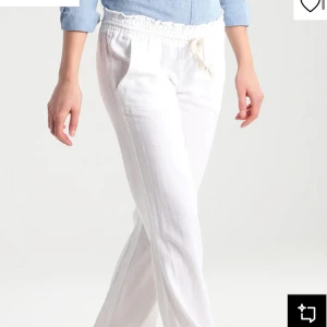 Vita linnebyxor med snörning - Snygga vita linnebyxor med avslappnad passform och dragsko i midjan. Byxorna har raka ben och sidfickor, perfekta för en chill och fräsch look. Lätta och luftiga, passar grymt till sommaren.