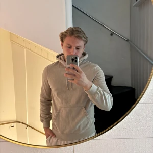 Beige hoodie från H&M - Säljer en beige hoodie från H&M i relaxed fit. Tröjan har huva med dragsko och en stor magficka framtill. Perfekt för en avslappnad stil och enkel att matcha med det mesta.
