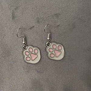 Tassavtryck örhängen söta  - Så söta örhängen i form av tassar. Ca 1,2 x 1,5 cm. 