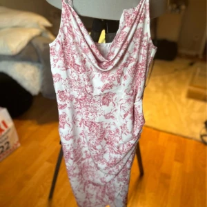 Vit och rosa mönstrad klänning från Missguided - Säljer en vit klänning med rosa blommigt mönster från Missguided. Klänningen har draperad urringning och är ärmlös med smala axelband. Perfekt för sommarens tillfällen och har en figurnära passform.🩷
