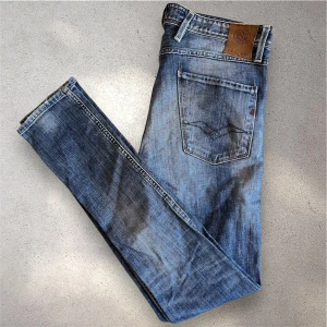 Blå Replay Anbass jeans - Säljer ett par klassiska blå Replay Anbass jeans med snygg tvätt och slim fit. Storleken är 31