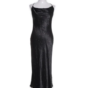Svart långklänning med glitter från LeGer by Lena Gercke - Snygg svart långklänning från LeGer by Lena Gercke med tunna axelband och glittrigt mönster. Klänningen har en elegant, figurnära passform och är perfekt för festliga tillfällen. Materialet är mjukt och skimrande för en lyxig känsla.