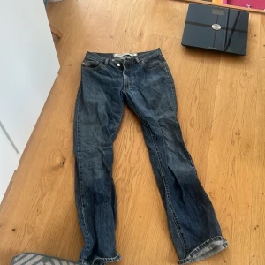 Blå jeans från Diesel Industry - Säljer ett par klassiska blå jeans från Diesel Industry. Jeansen har raka ben, fem fickor och snygga kontrastsömmar. Tillverkade i slitstarkt denim med en cool tvättad look. Perfekta för dig som gillar en tidlös och avslappnad stil.