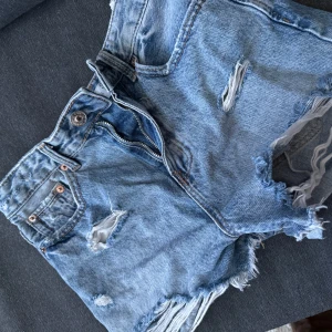 Blå jeansshorts från Stradivarius - Snygga blå jeansshorts från Stradivarius i storlek 34. De är midwaist shorts och aldrig använda. 