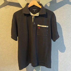 Svart pikétröja från Burberry - Säljer en svart pikétröja från Burberry. I helt okej skick och riktigt skön till sommaren🔥.              OBS! Storleken säger L men är snarare S! 