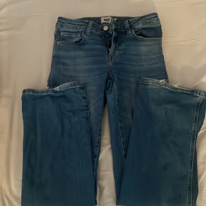 Blå bootcut jeans från 157 - Säljer ett par blå bootcut jeans från 157 i storlek XS och short längd. Jeansen har klassisk femficksdesign, knapp- och dragkedjestängning samt snygga bakfickor med lock. 