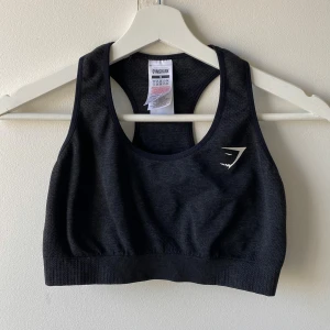 Svart sport-bh från Gymshark - Säljer en svart sport-bh från Gymshark med brottarrygg och diskret logga framtill. Storlek M men passar S också