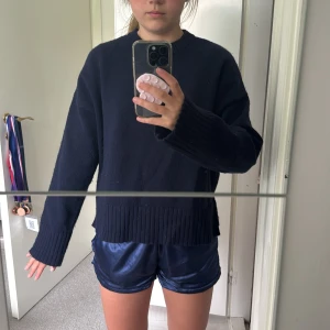 Mörkblå stickad tröja från Bershka - Mörkblå stickad tröja från Bershka. Tröjan har bred ribbad kant nedtill och vid ärmsluten, rund halsringning och långa ärmar. Perfekt för lager-på-lager och chill dagar. Snygg basic som funkar till allt.