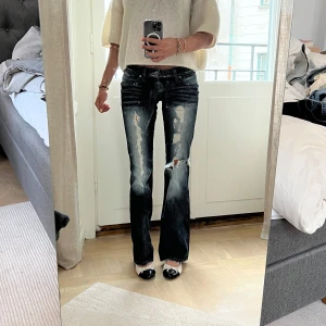 Mörkblå bootcut jeans från Guess - Säljer ett par mörkblå bootcut jeans från Guess med slitningar. Storlek 34. Sitter snyggt och är i fint skick. Jag är 169 cm lång, och på bilderna är mitt innerbensmått ca 82,5 cm och midjemått (platt mätt på mig) ca 31 cm.