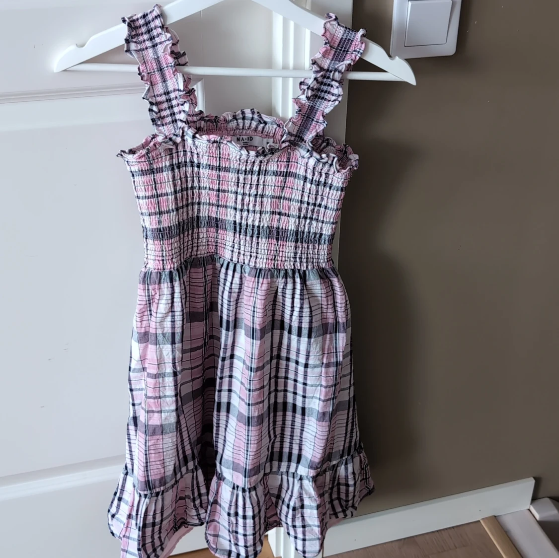 Rutig rosa och svart klänning med volang