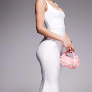 Vit långklänning med smala axelband - Säljer en elegant vit långklänning med smala axelband och figurnära passform. Klänningen har en stilren design med dragkedja i ryggen och markerad midja. Perfekt för speciella tillfällen som tex student eller examen. Helt ny och oanvänd med prislapp kvar. Köpt för 879kr.