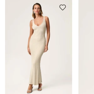  Lugo slip dress Adoore  - Säljer en snygg beige långklänning med ribbad struktur och v-ringad hals. Klänningen har smala axelband och figurnära passform som framhäver siluetten. Perfekt för sommarens alla tillfällen!