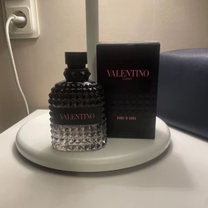 Valentino Uomo Born In Roma Eau de Toilette - Lyxig herrparfym från Valentino, Born In Roma. Flaskan är transparent med nitar och svart kork, etikett i svart och rosa. Doften är modern och elegant, perfekt för dig som vill sticka ut. Parfymen är aldrig använd och skriv för mer funderingar 💯