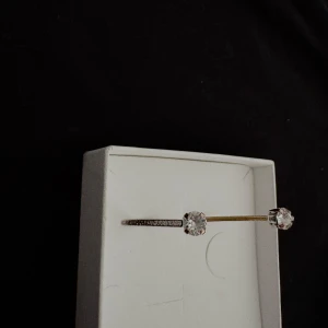 Caroline Svedbom armband med stenar - Snyggt silverfärgat armband med två klara stenar i varje ände från Caroline Svedbom. Armbandet har även små glittriga detaljer längs bandet för extra bling. Perfekt accessoar för att lyfta din outfit.